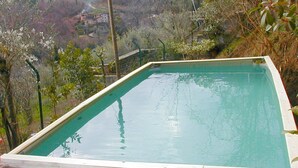 A rectangular swimming pool with a clear view of a mountainous landscape in the background. - Cottage in Marliana With Private Pool (Marliana)