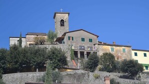 A historic building with a bell tower, a balcony, and a stone wall. - Cottage in Marliana With Private Pool (Marliana)