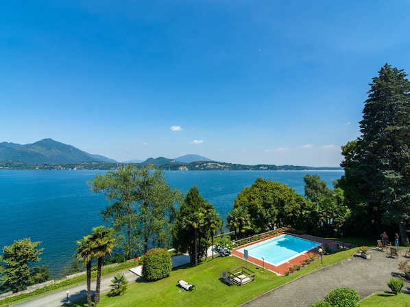 A pool with a clear view of the lake and mountains in the background.