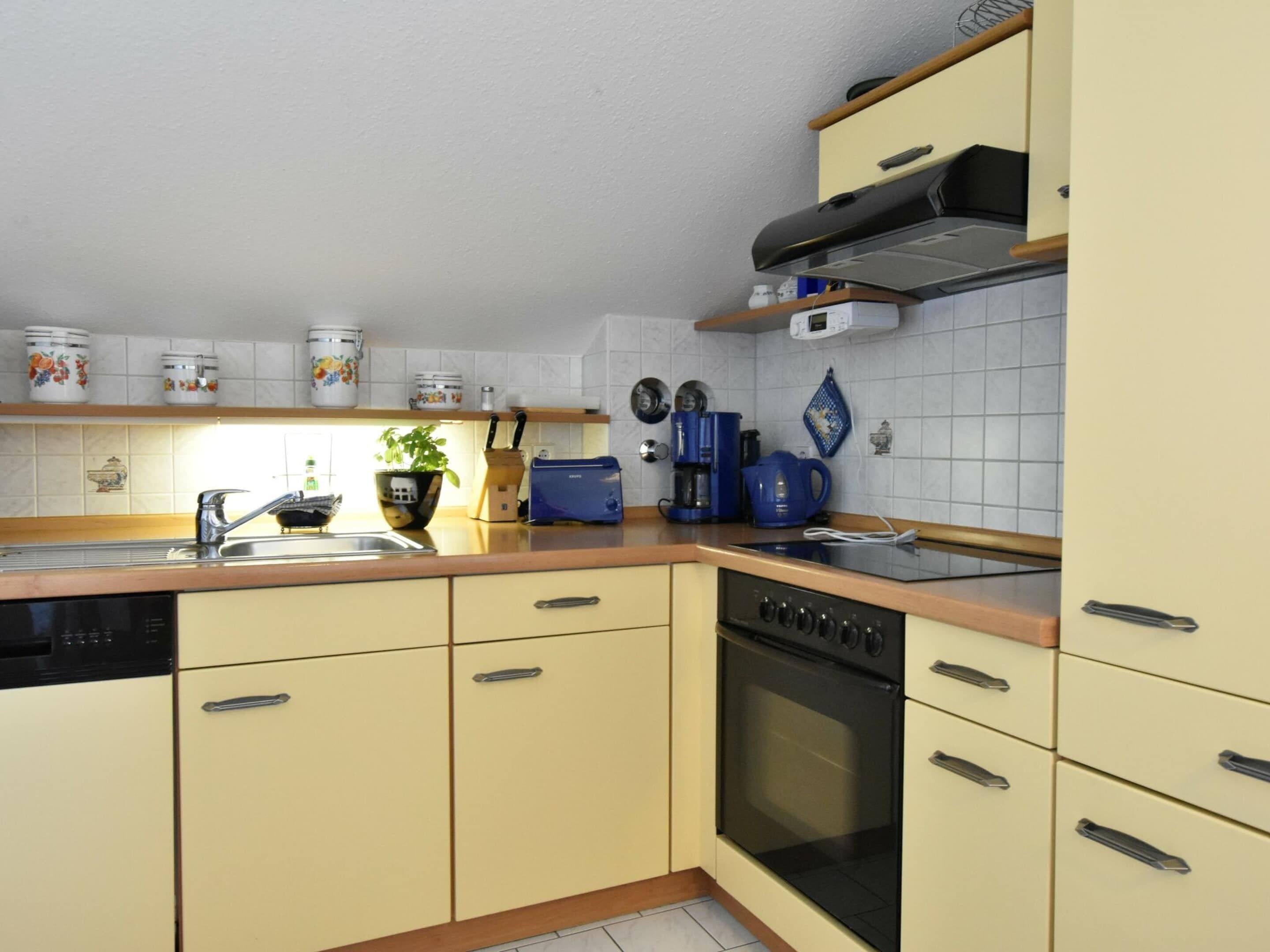 A kitchen with a dishwasher, stove, oven, and various appliances like a toaster and coffee maker.