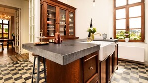 A kitchen with a large island, wooden cabinets, and a checkered floor. - Beautiful Villa With Sauna in Chiny (Chiny)