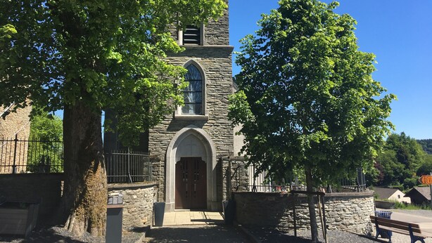 A stone church with a wooden door and arched windows, surrounded by trees and a stone wall. - Family Apartment; Bouillon and Semois River (Bievre)