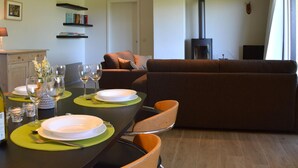 A dining area with a table set for two, a sofa, and a fireplace. - Family Apartment; Bouillon and Semois River (Bievre)
