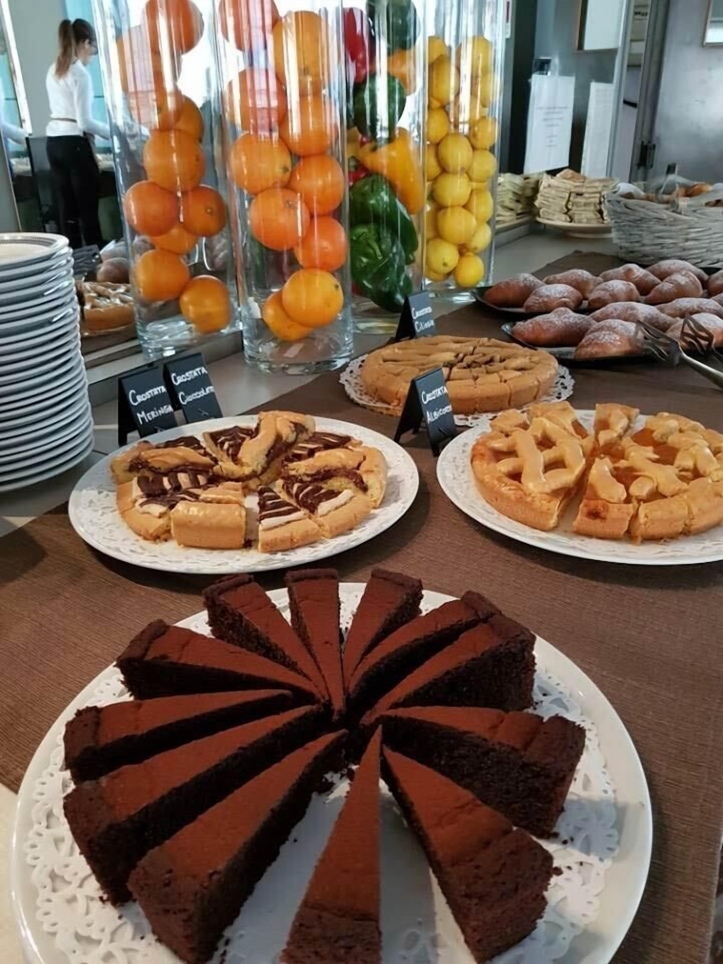 Een presentatie van diverse desserts, waaronder chocoladetaart, citroentartaars en gebak.