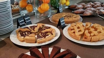 Eine Auswahl an Desserts, darunter ein Schokoladenkuchen, Zitronentörtchen und Gebäck.