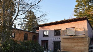 A modern two-story house with a wooden deck and a stone facade. - Grosses Ferienhaus Fuer 8 Personen, Manderscheid (Manderscheid)