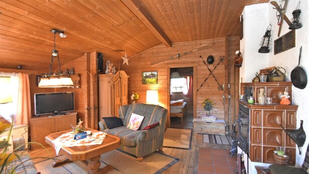 A cozy wooden cabin interior with a sofa, television, and a dining table. - Detached Wooden House with Fireplace & Large Garden near Bad Wildungen (Haina)