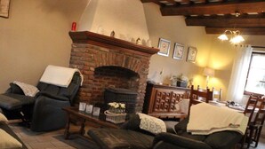 A cozy living room with a brick fireplace, leather sofas, and a wooden coffee table. - Lakeside Getaway in Bouillon (Paliseul)
