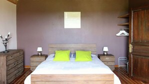 A bedroom with a wooden bed, two nightstands, a hanging lamp, a wall-mounted light, and a wooden wardrobe. - Spacious Country Villa (Neufchateau)