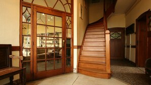 A wooden staircase leading to a second floor, a wooden door with glass panels, and a patterned floor. - Home Near Bouillon Castle (Bouillon)