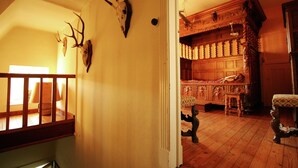 A room with wooden flooring, a wooden bench, a wooden cabinet, and a staircase with a wooden railing. - Home Near Bouillon Castle (Bouillon)