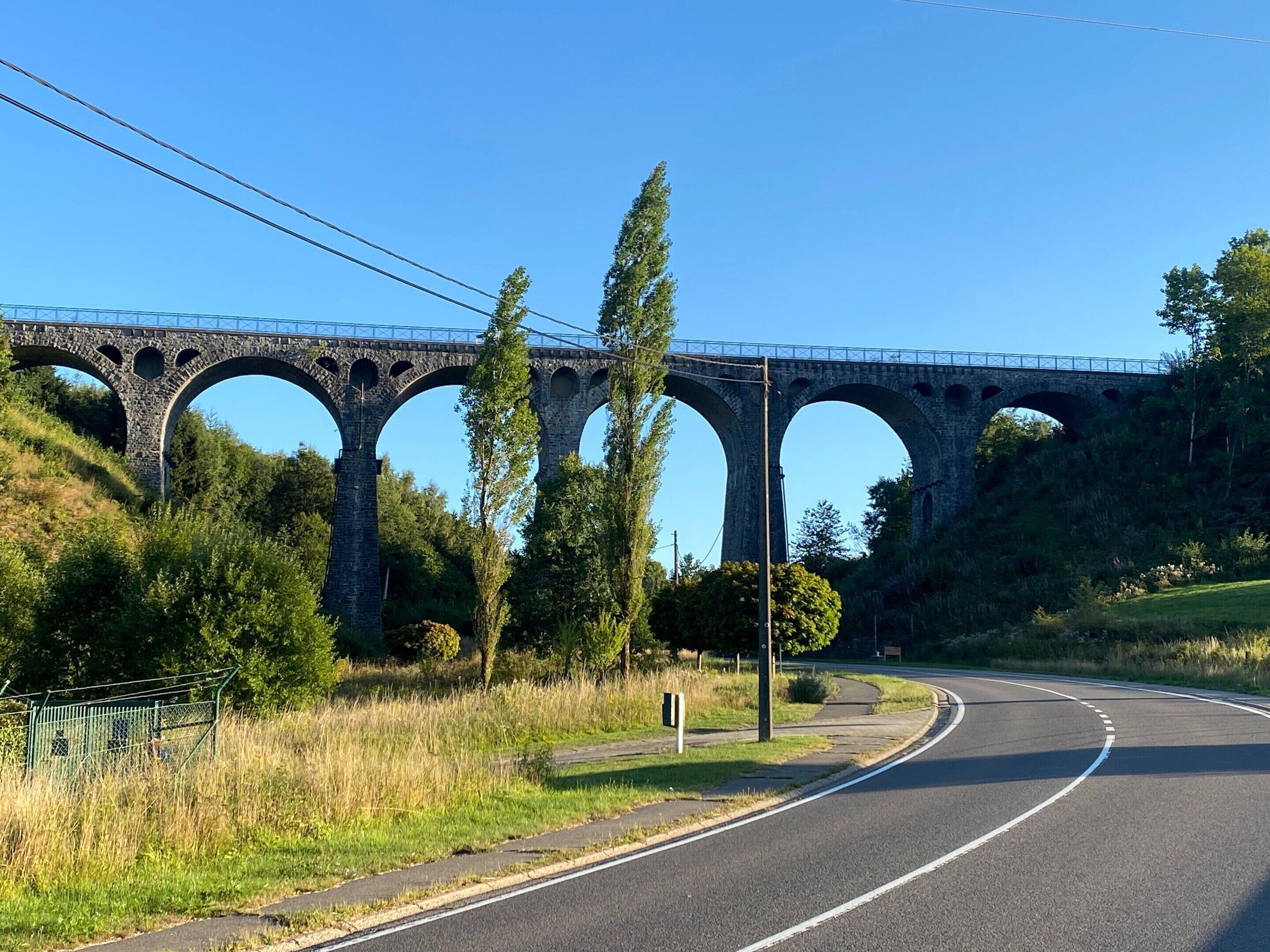 Un ponte in pietra con più archi sopra una strada.