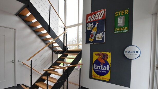 A modern interior with a black and wooden staircase, a white door, and various posters on the wall. - Villa in Luttenberg Near National Park (Luttenberg)