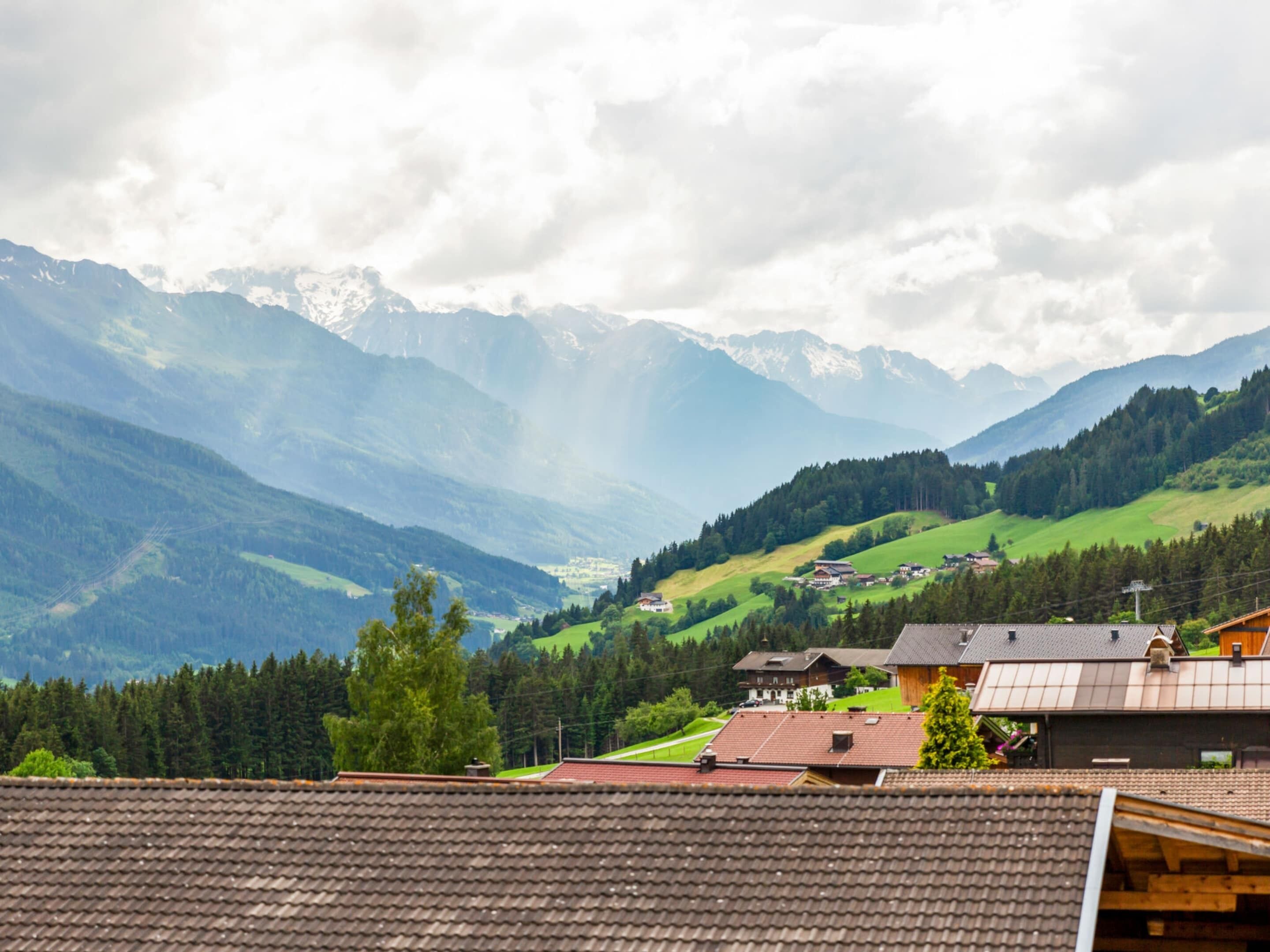 Un village de montagne aux maisons traditionnelles, offrant une vue dégagée sur les montagnes environnantes et surplombant une vallée.