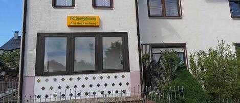 A two-story building with a sign reading "Ferienwohnung 'Am Beck'nsberg".