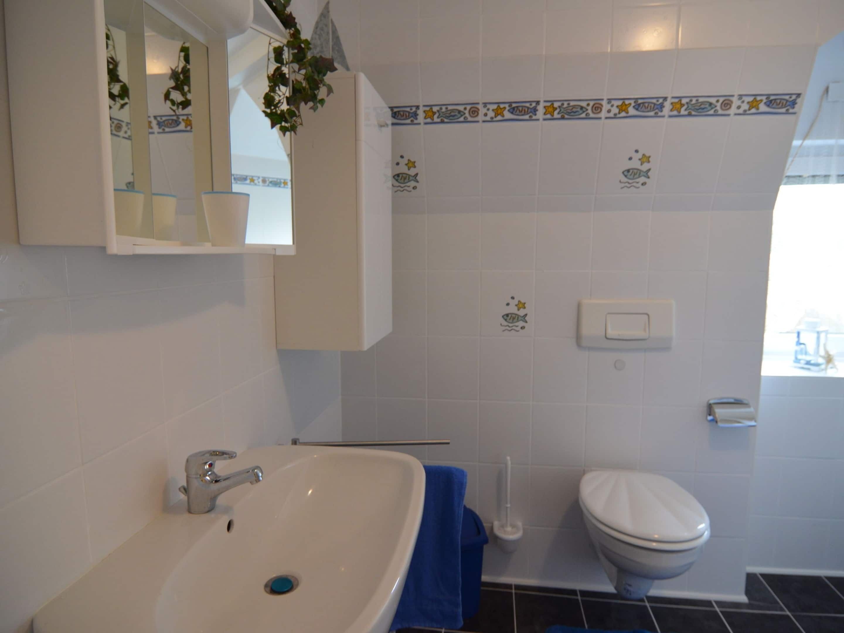 Ein Badezimmer mit Waschbecken, Toilette und Spiegel.