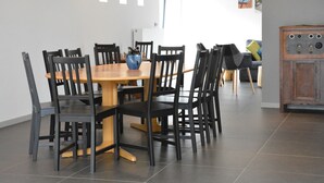 En matplats med ett träbord och svarta stolar, en blå vas på bordet och ett grått skåp med en rustik design.