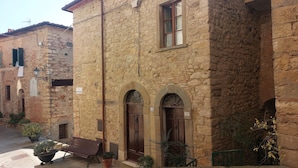 A stone building with arched doorways and a bench outside. - Tuscan Hilltop Getaway (Castelnuovo di Val di Cecina)