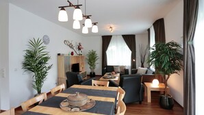 A modern living room with a dining area, wooden furniture, and potted plants. - Serene Villa in Kstelberg near Lake & Watersports (Medebach)