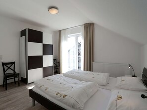 A bedroom with a bed, a chair, a wardrobe, and a window with curtains. - Serene Villa in Kstelberg near Lake & Watersports (Medebach)