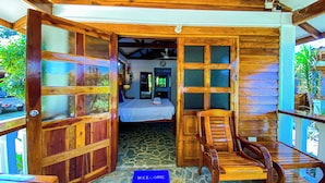 Eine Holzhütte mit einem Bett, einem Holzstuhl und einer Fußmatte.
