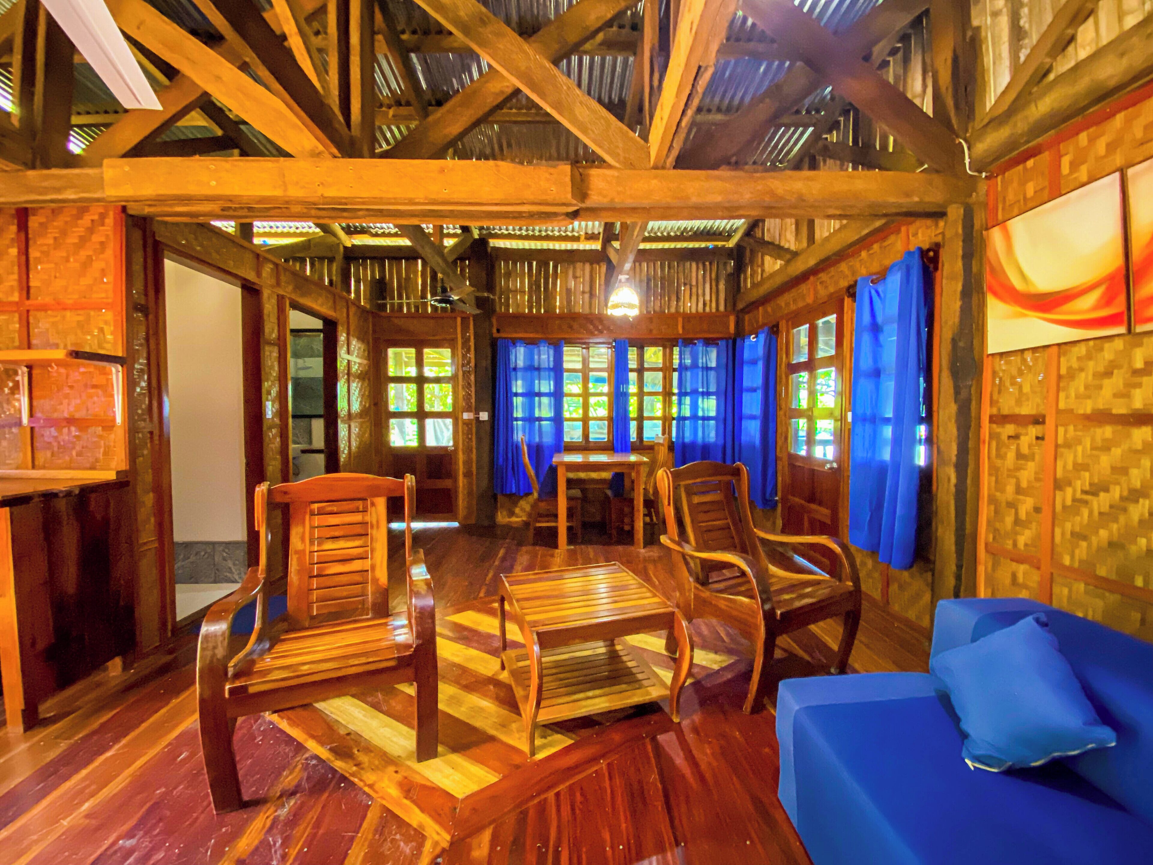 Un interior de madera con una mesa de comedor, sillas y un sofá azul.