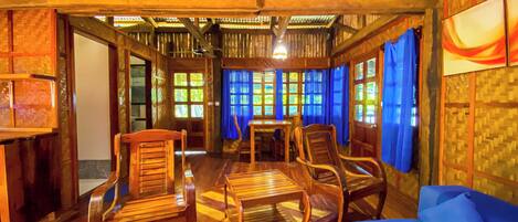Un interior de madera con una mesa de comedor, sillas y un sofá azul.