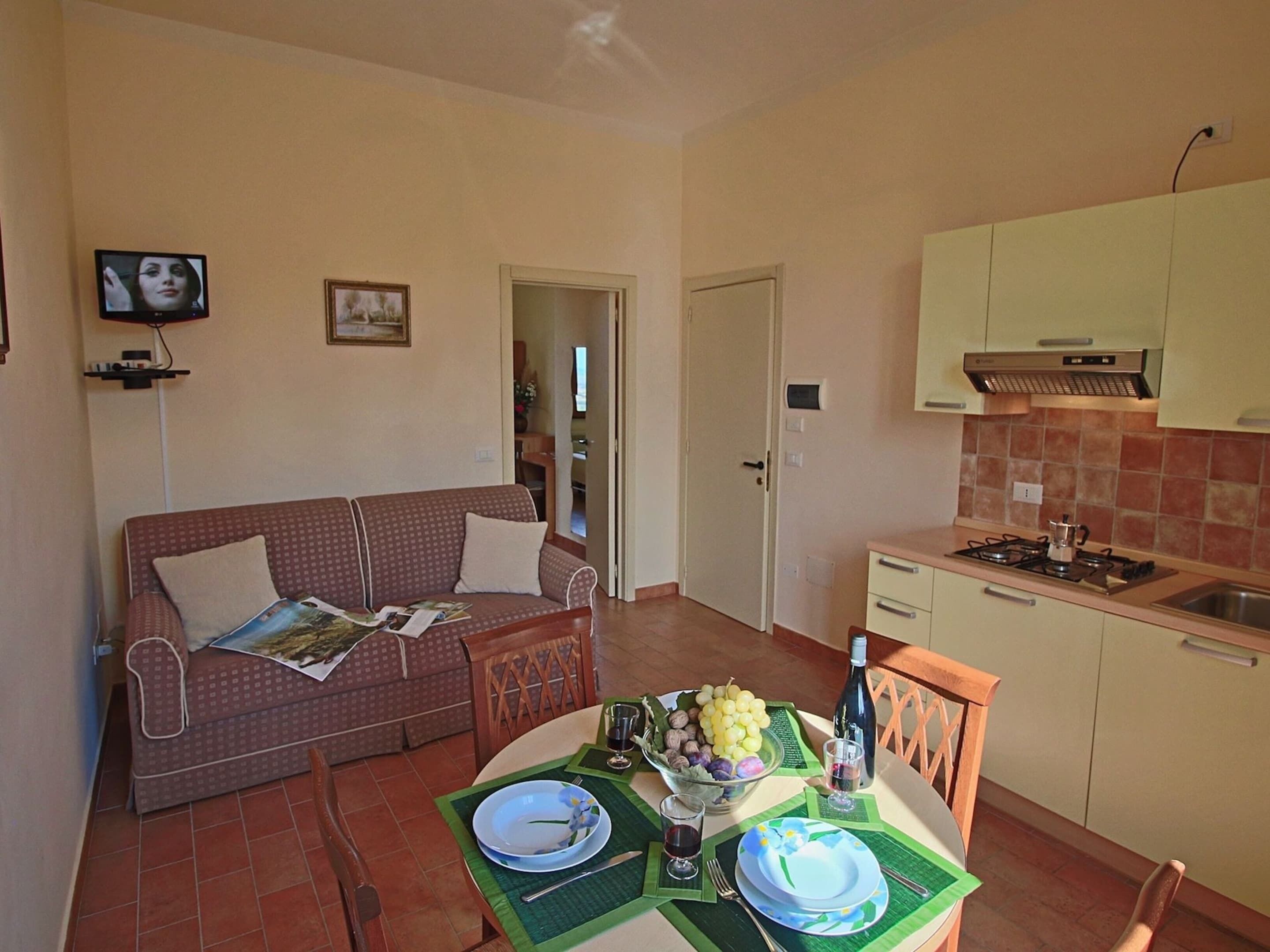 A compact living space with a kitchenette, a dining area, and a sofa.