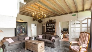 A living room with a chandelier, sofas, a wooden chest, and a patterned armchair. - Beernem Farmhouse With Pool (Beernem)