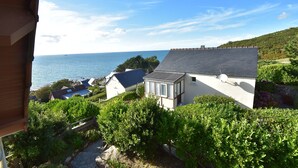 A coastal property with a view of the sea, a house with a satellite dish, and lush greenery. - Sea View Stay in Fermanville (Fermanville)