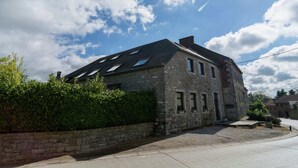 Un bâtiment en pierre doté de nombreuses fenêtres et d’un toit en pente.
