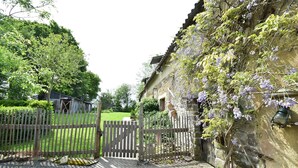 A rustic stone building with a wooden gate, a gravel path, and lush greenery. - Gouvets Family Retreat (Gouvets)