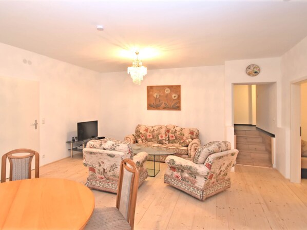 Relax in this inviting living space with a sofa, dining table, and TV.