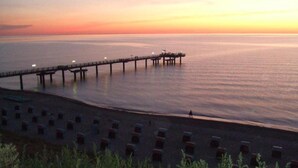 A pier extending into calm waters at sunset. - Exklusives Reetdachhaus mit Sauna in Rerik (Rerik)