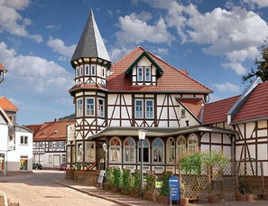 A traditional half-timbered building with a prominent tower and a red-tiled roof.