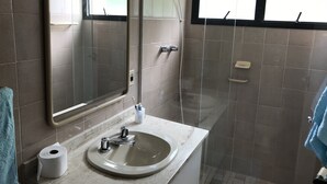 Ein Badezimmer mit Waschbecken, Spiegel und Dusche.