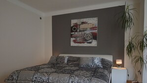 A bedroom with a bed, a nightstand, a lamp, and a potted plant. - Apartment in Trittenheim With Terrace and Garden (Trittenheim)