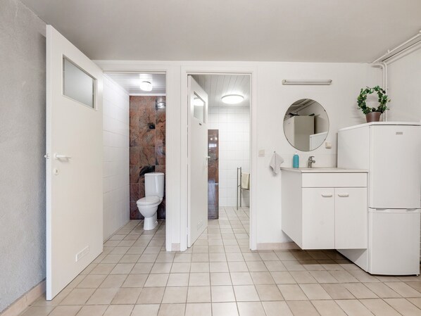 A modern bathroom with a toilet, sink, and mirror. - Charming Oombergen Mill Retreat (Zottegem)