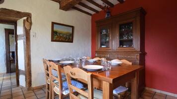 A dining room with a wooden table set for four, surrounded by chairs.