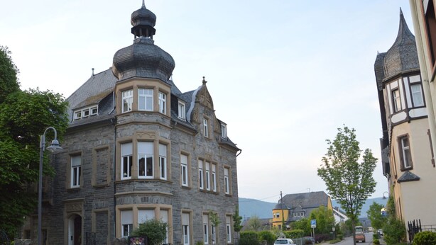 A historic stone building with a turret and bay windows, located on a cobblestone street. - Cozy Apartment in Neumagen-Dhron near Lake Mosel with Garden (Neumagen-Dhron)