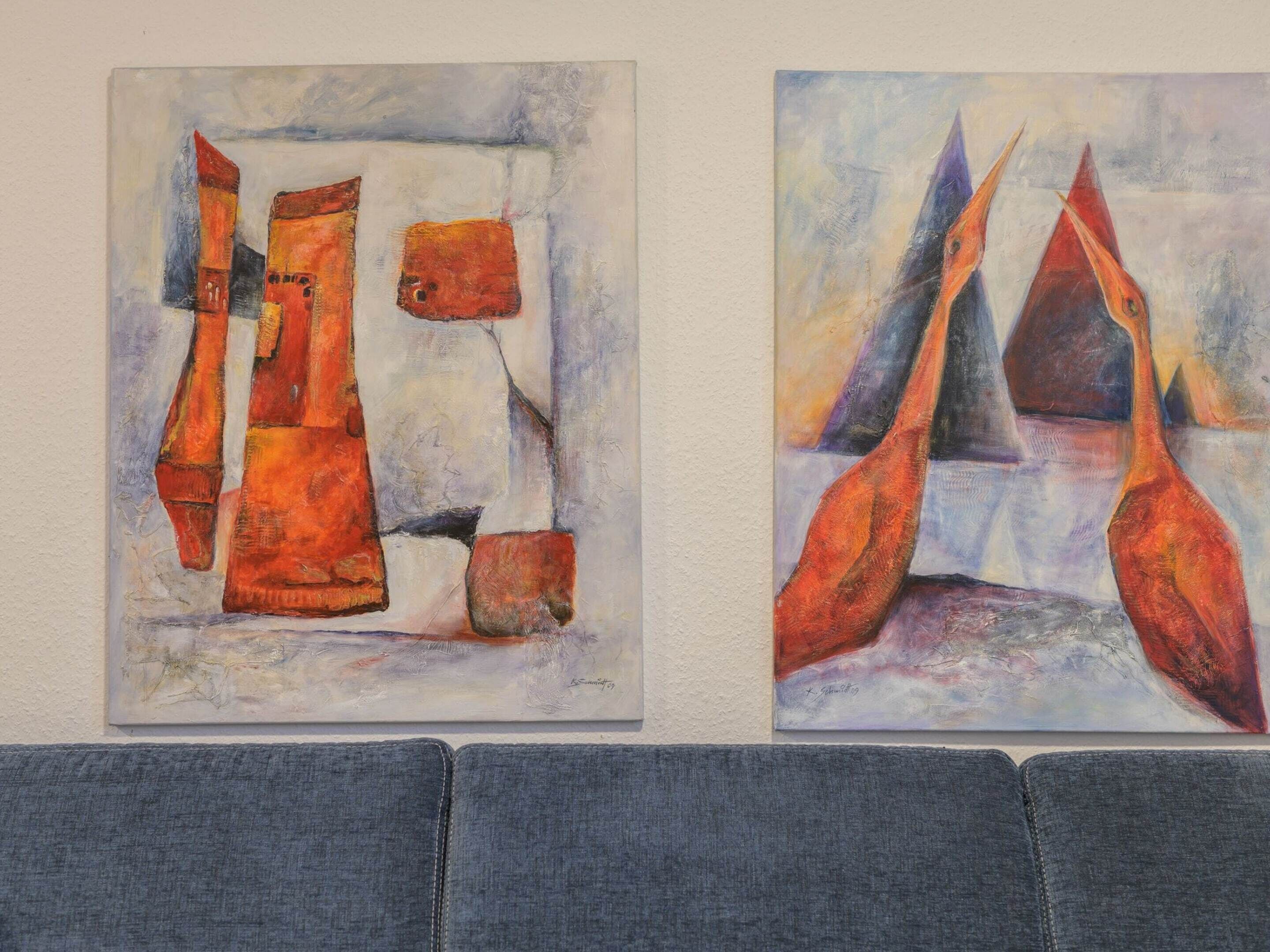 Deux tableaux abstraits accrochés à un mur.