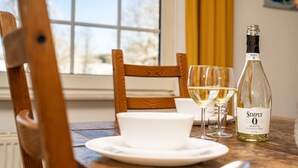 A dining table with a bottle of white wine, glasses, and a bowl. - Large Holiday Home near Winterberg with Garden, Terrace, & Garage (Winterberg)