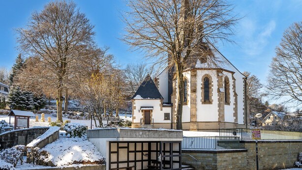 A church with a bell tower, a covered entrance, and snow on the ground. - Large Holiday Home near Winterberg with Garden, Terrace, & Garage (Winterberg)