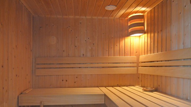A wooden sauna with benches and a bucket. - Lovely Group House near Winterberg with Private Sauna, Garden, & Terrace (Hallenberg)