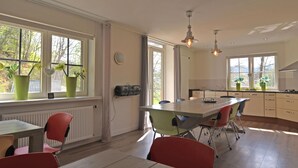 A modern kitchen with a dining area, large windows, and potted plants. - Lovely Group House near Winterberg with Private Sauna, Garden, & Terrace (Hallenberg)