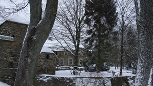 A stone building with a snow-covered roof and a sign that reads "Hotel". - Chic Mansion in Robertville (Waimes)