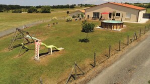 Una casa con piscina, un cortile recintato e altalene.