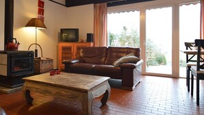 A living room with a fireplace, a sofa, a coffee table, and a television. - Holiday Home in Gemmenich With Forest Views (Plombieres)