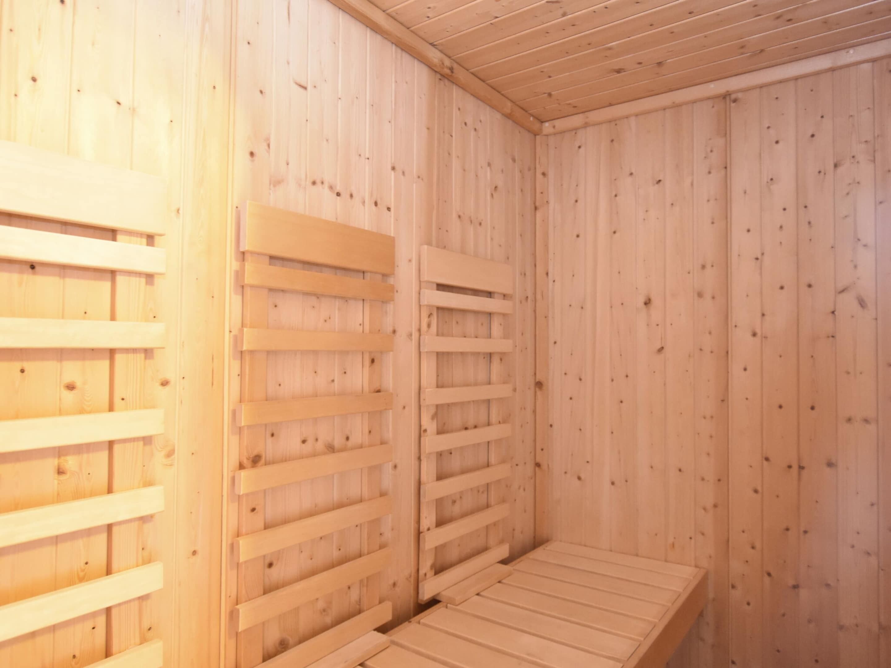 A sauna room with wooden walls and benches.
