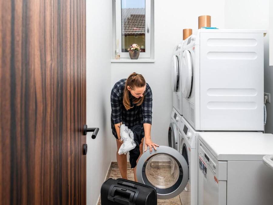 Une buanderie équipée d’un lave-linge, d’un sèche-linge et de plusieurs sèche-linge superposés.